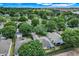 Panoramic aerial view of a residential community with mature trees and well-spaced homes under a blue sky at 4167 Capland Ave, Clermont, FL 34711