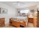 Cozy bedroom with wooden bed frame, matching nightstand and dresser, and neutral carpet at 4167 Capland Ave, Clermont, FL 34711