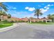 Clubhouse entry features landscaped grounds, beautiful flowering plants and palm trees at 4167 Capland Ave, Clermont, FL 34711