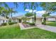 Charming single-story home with a well-manicured lawn, lush landscaping, and a brick driveway at 4167 Capland Ave, Clermont, FL 34711