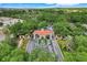 Aerial view showcases a gated entrance with a fountain, manicured landscaping, and surrounding lush greenery at 4167 Capland Ave, Clermont, FL 34711