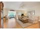 Cozy living room with light hardwood floors, ceiling fan, and lots of natural light at 4167 Capland Ave, Clermont, FL 34711