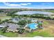 Aerial view of a community clubhouse, with pool, parking, and a scenic lake backdrop at 4167 Capland Ave, Clermont, FL 34711