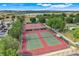 Aerial shot of well-maintained tennis courts with ample parking and lush greenery, enhancing community appeal at 4167 Capland Ave, Clermont, FL 34711