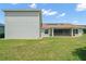 Green lawn and exterior view of the home's rear with a screened lanai at 4320 Heritage Trl, Leesburg, FL 34748