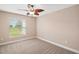 Bedroom with carpet, ceiling fan, and a window view of the lush yard at 4320 Heritage Trl, Leesburg, FL 34748