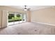 Spacious bedroom with carpet, ceiling fan, and sliding glass doors to the outside at 4320 Heritage Trl, Leesburg, FL 34748