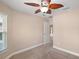 Cozy bedroom with carpet, ceiling fan, and a view looking out into the hallway at 4320 Heritage Trl, Leesburg, FL 34748