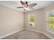 Cozy bedroom with neutral carpet, ceiling fan, and bright windows looking out to the neighborhood at 4320 Heritage Trl, Leesburg, FL 34748