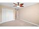 Bedroom with neutral carpet and walls, ceiling fan, and large closet for storage at 4320 Heritage Trl, Leesburg, FL 34748