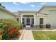 Beautiful front entrance featuring a screened doorway, stone accents, and attractive landscaping at 4320 Heritage Trl, Leesburg, FL 34748
