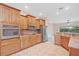Kitchen with stainless steel appliances, wooden cabinetry, and tile backsplash at 4320 Heritage Trl, Leesburg, FL 34748