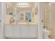 Bathroom with a double sink vanity, large mirror, and floral wallpaper at 4720 Summerbridge Cir, Leesburg, FL 34748