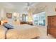 Bright bedroom with a ceiling fan, window, dresser, and adjacent bathroom at 4720 Summerbridge Cir, Leesburg, FL 34748