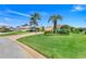 Well-manicured lawn with tropical landscaping and a long driveway leading to a charming one-story home at 4720 Summerbridge Cir, Leesburg, FL 34748