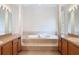 Spacious bathroom featuring a garden tub, and sinks, and decorative columns at 4908 Cape Hatteras Dr, Clermont, FL 34714