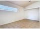 A bright bedroom offers neutral paint, tile flooring, a window for natural light and clean trim at 4908 Cape Hatteras Dr, Clermont, FL 34714