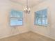 Bright dining room featuring large windows, a decorative chandelier, and neutral decor creating an inviting atmosphere at 4908 Cape Hatteras Dr, Clermont, FL 34714