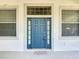 Close-up of a well-maintained front door with sidelights and transom window for added natural light at 4908 Cape Hatteras Dr, Clermont, FL 34714