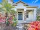 Inviting front entrance with stone accents, a beautifully colored door, and lush tropical landscaping at 4908 Cape Hatteras Dr, Clermont, FL 34714