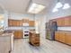 Open kitchen with a skylight, stainless steel refrigerator, central island, and wood cabinets at 4908 Cape Hatteras Dr, Clermont, FL 34714