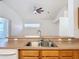 Open concept kitchen with an island, wood cabinets, and stainless-steel sink at 4908 Cape Hatteras Dr, Clermont, FL 34714