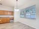 Bright kitchen features hardwood floors, a window with blinds, and warm wood cabinets at 4908 Cape Hatteras Dr, Clermont, FL 34714