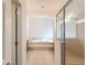 Luxurious main bathroom with a soaking tub, a separate glass shower, and neutral tile at 4908 Cape Hatteras Dr, Clermont, FL 34714
