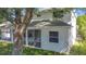 A view of the rear exterior of the home with a screened-in patio, backyard, and partial tree cover at 4908 Cape Hatteras Dr, Clermont, FL 34714