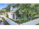 A view of the back of the home showing the screened-in lanai, lawn, and white privacy fence at 4908 Cape Hatteras Dr, Clermont, FL 34714