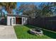 Backyard storage shed with double doors and an adjacent fire pit, perfect for outdoor gatherings at 5011 Se 33Rd Ave, Ocala, FL 34480