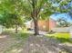 Large, private backyard featuring mature trees, green lawn, and a cozy patio area perfect for outdoor entertaining at 520 Rob Roy Dr, Clermont, FL 34711