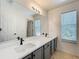 Bathroom featuring double sink, quartz countertops, updated light fixture, large mirror, and window at 520 Rob Roy Dr, Clermont, FL 34711