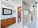 Bright bathroom features a glass enclosed shower, vanity with storage, and white tile flooring at 520 Rob Roy Dr, Clermont, FL 34711