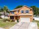 Charming two-story home with a two car garage, manicured lawn, and colorful landscaping at 520 Rob Roy Dr, Clermont, FL 34711