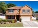 Charming two-story home with a two car garage, manicured lawn, and colorful landscaping at 520 Rob Roy Dr, Clermont, FL 34711