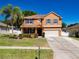 Charming two-story home with a two car garage, manicured lawn, and colorful landscaping at 520 Rob Roy Dr, Clermont, FL 34711