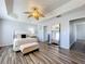 Primary bedroom with wood-look floors, a trey ceiling, ceiling fan, and view into the bathroom at 520 Rob Roy Dr, Clermont, FL 34711