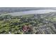 Aerial view of the property near a lake, highlighting its location surrounded by lush greenery and a residential area at 5495 County Road 125, Wildwood, FL 34785