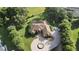 Expansive aerial view of estate home highlighting the pool, surrounding acreage, and circular driveway with fountain at 5495 County Road 125, Wildwood, FL 34785