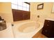 An inviting bathroom features a large beige soaking tub and dark brown shutters at 5495 County Road 125, Wildwood, FL 34785