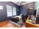 This is a bedroom with dark blue walls with a window, bed and desk at 5495 County Road 125, Wildwood, FL 34785