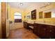 Beautiful main bathroom features dual vanities, dark wood cabinets, tile flooring, and a luxurious soaking tub at 5495 County Road 125, Wildwood, FL 34785