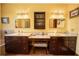 This main bathroom features dual vanities with dark wood cabinets, tile flooring, and elegant lighting fixtures at 5495 County Road 125, Wildwood, FL 34785