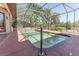 The screened-in, in-ground pool offers a refreshing escape, complemented by tile accents and a relaxing ambiance at 5495 County Road 125, Wildwood, FL 34785