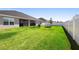 Spacious backyard featuring lush green grass, outdoor seating, and partial fence at 5890 Sw 83Rd St, Ocala, FL 34476