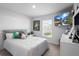 Light filled bedroom featuring carpet, ceiling fan, mounted TV and a double window at 5890 Sw 83Rd St, Ocala, FL 34476