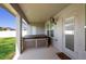 Covered patio with hot tub, ceiling fan, and door leading to home interior and backyard at 5890 Sw 83Rd St, Ocala, FL 34476