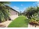 Well-manicured backyard with lush green grass, landscaping, and tropical plants, creating a serene outdoor space at 6104 Hunters Ridge Ave, Leesburg, FL 34748