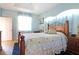 Cozy bedroom with a wooden bed frame, blue walls, and a window that lets in natural light at 6104 Hunters Ridge Ave, Leesburg, FL 34748